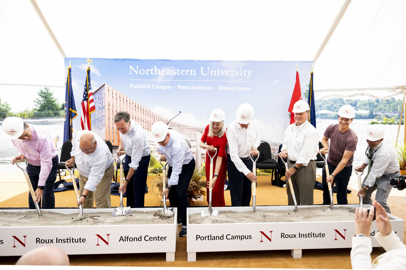 People wearing hard hats shoveling dirt at the Portland Campus ground breaking.