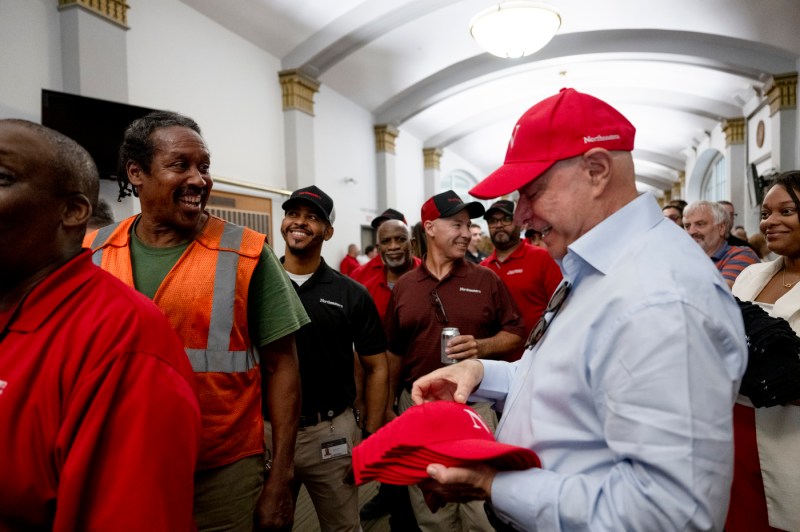 President Aoun passing out red baseball caps at the facilities BBQ. 