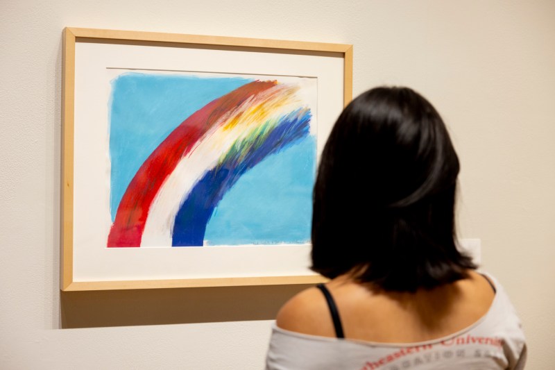 A person looking at a piece of artwork hung on the wall at the Mills College Art Museum.