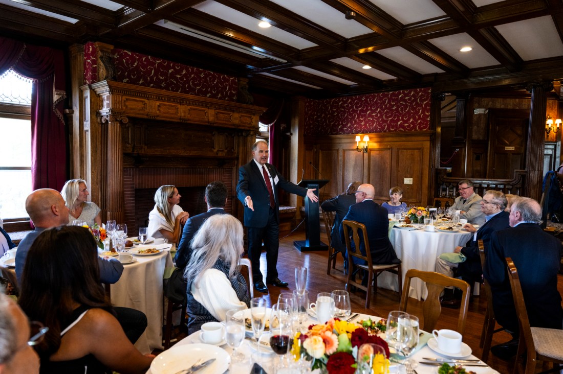 A group of Northeastern trustees and guests seated around a formal dining table at a special event.