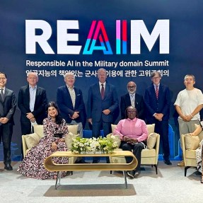 A group of people posing at the REAIM Summit.