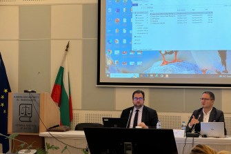 Anton Dinev standing in front of a projected screen giving training to Bulgarian judges.