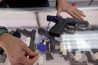 A handgun on the glass display case of a gun shop owner.