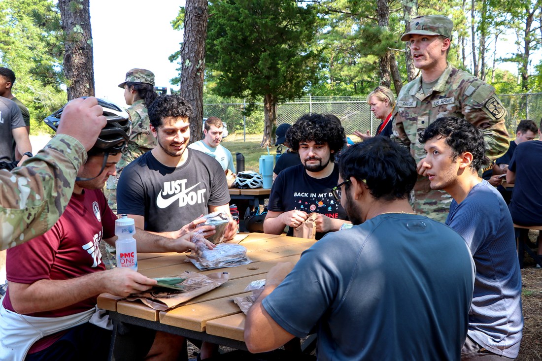 Students sitting around a wooden table. 