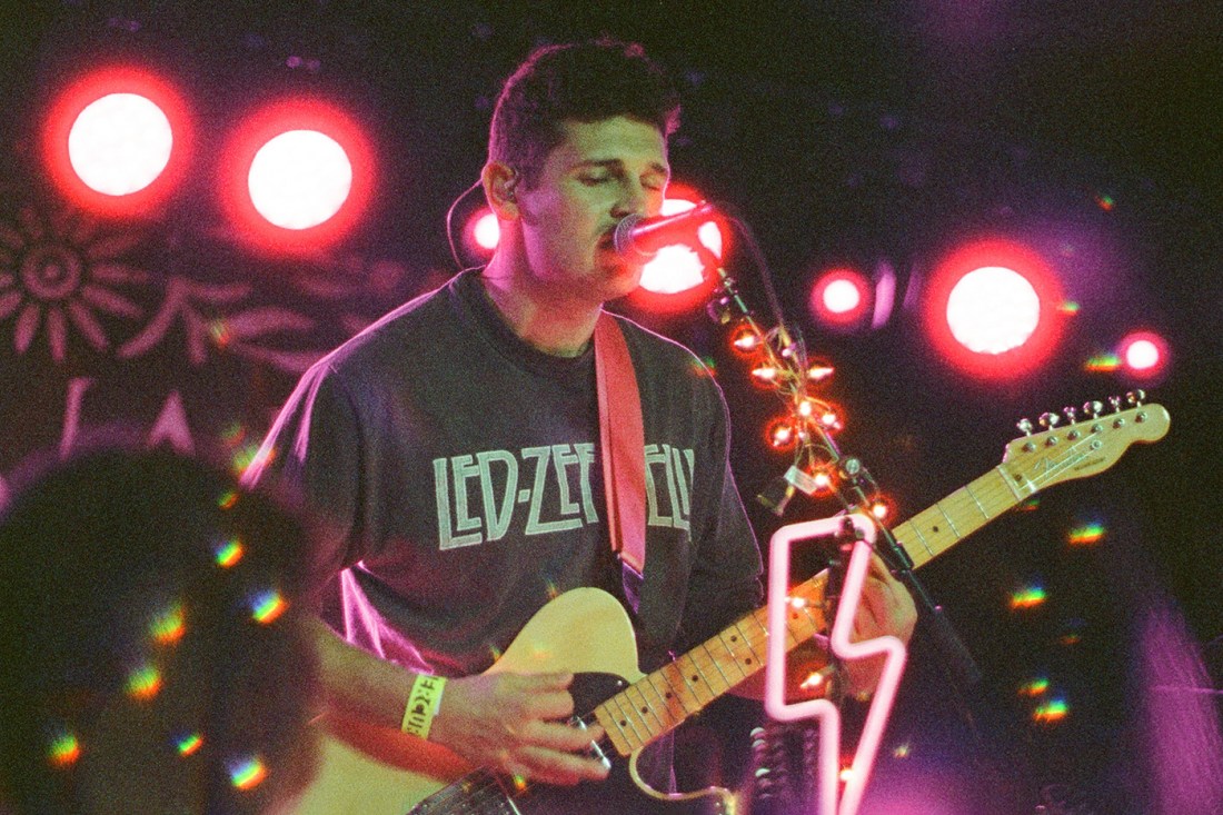 Dylan Rockoff singing and playing guitar on stage.