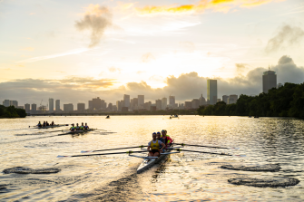 Athletes row on the Charles River as the sun rises.