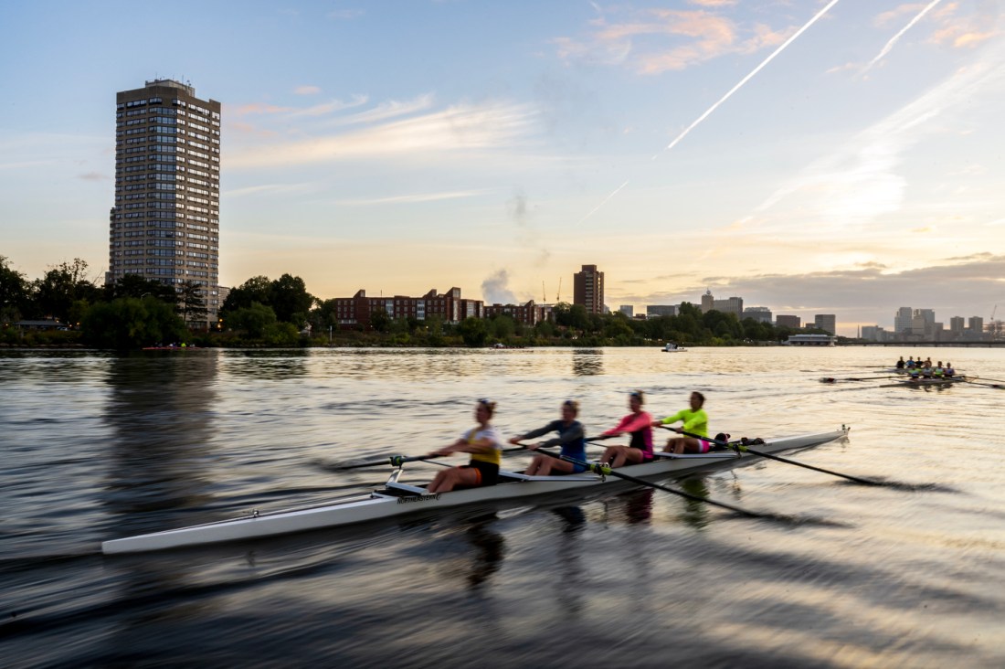 A blurred image of people in a boat rowing down a river.