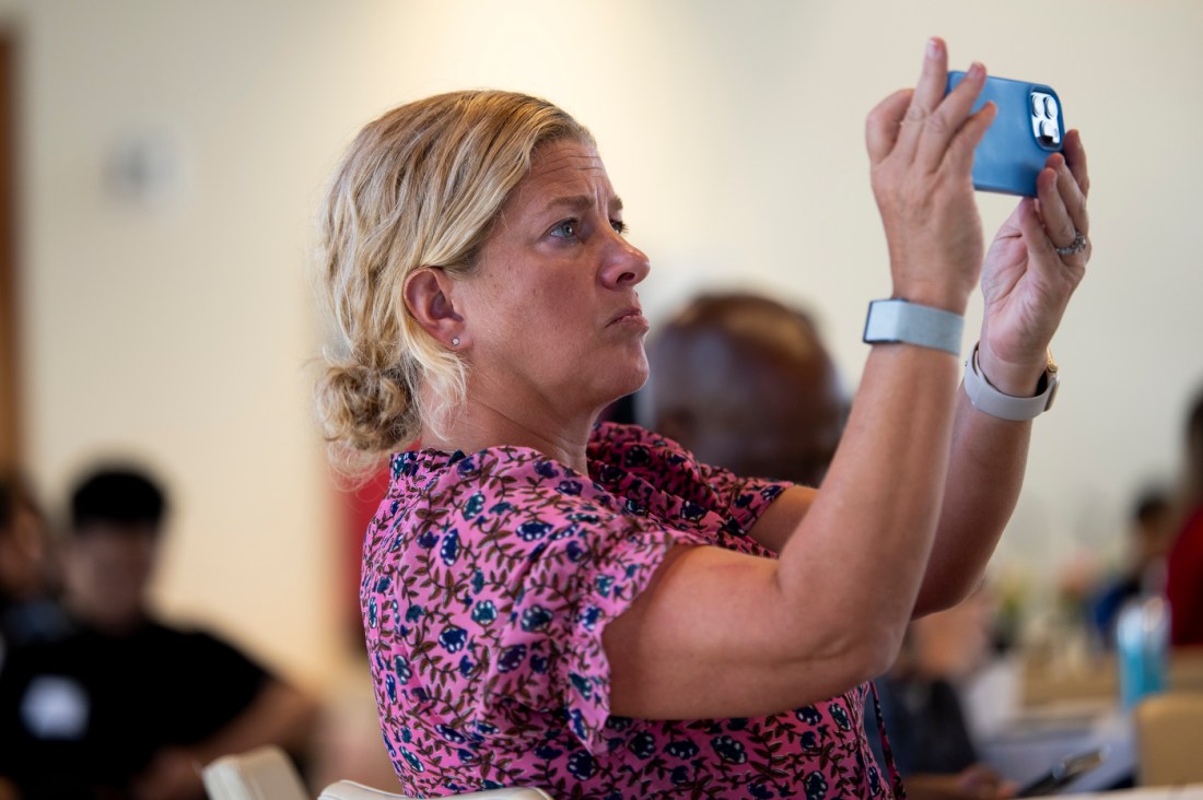 An audience member holding their phone up to take a photo.