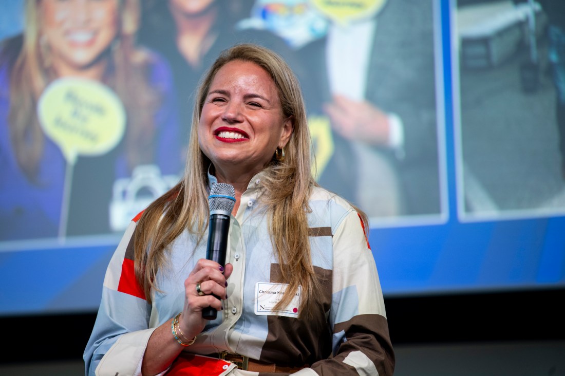 Christine Kosmowski smiling while holding a microphone. 