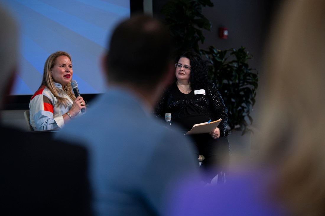 Two speakers sitting on stage at the Women of the Cloud College Tour.