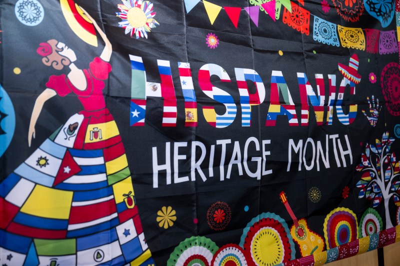 A large black sign with multi-colored text: "Hispanic Heritage Month".