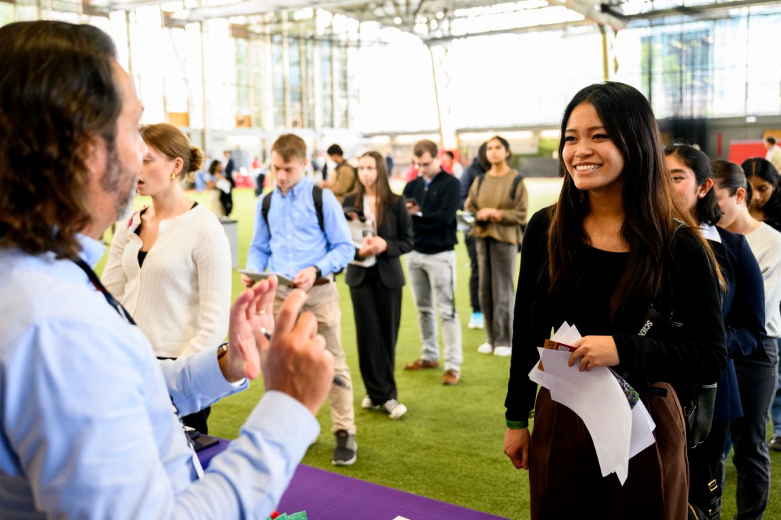 Students interact with employers at a university career fair.