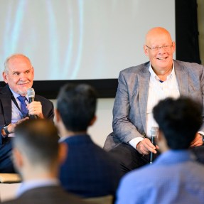 Two individuals have a conversation during a public event.