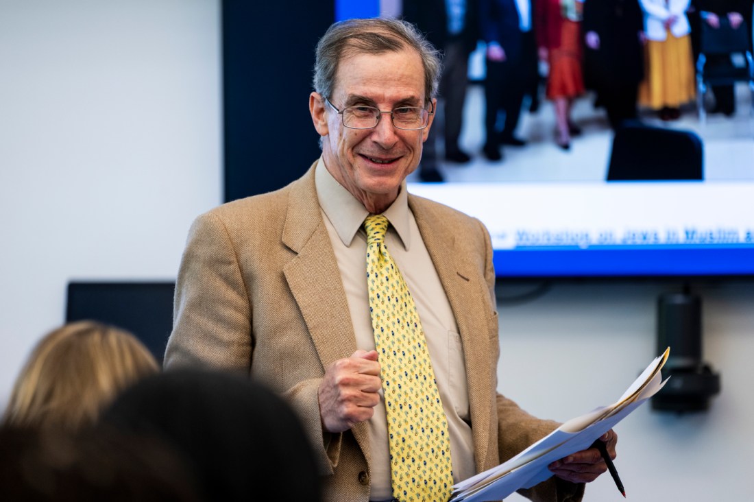 A person wearing a suit and tie smiling.