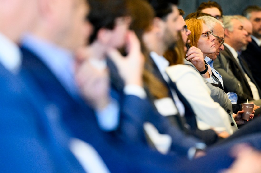 Audience members listening at an event.