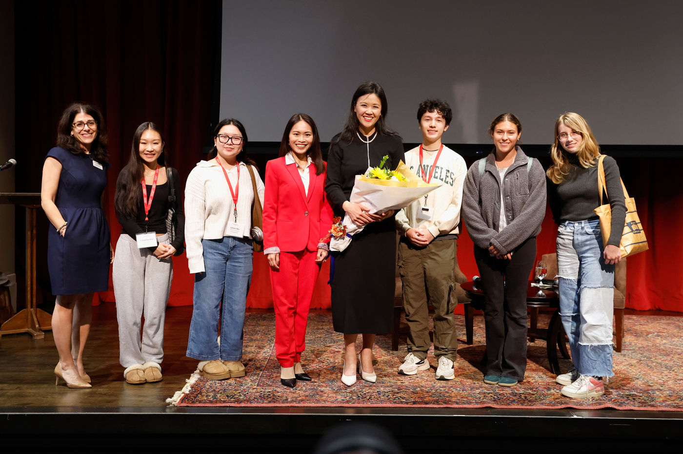 Dr Rita Ng posing with 7 other people. 