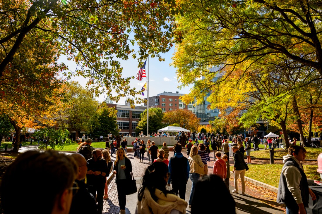 Crowds of people walk around Centennial Common on the Boston campus. 