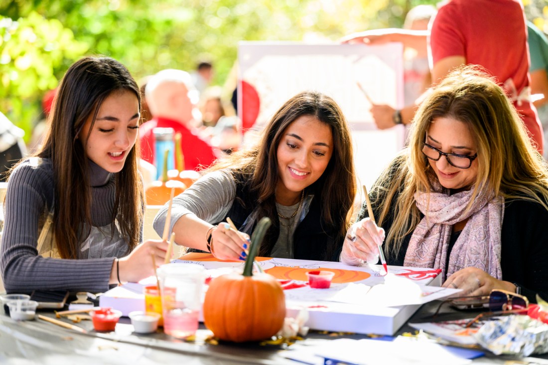 A student and their family paint together on the Boston campus. 