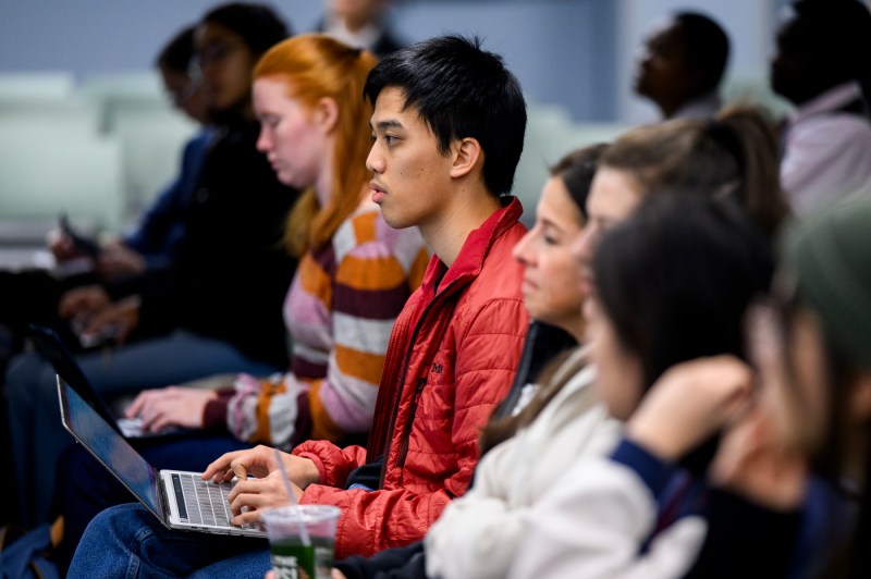 Audience members typing on their laptops at the State of the World series. 