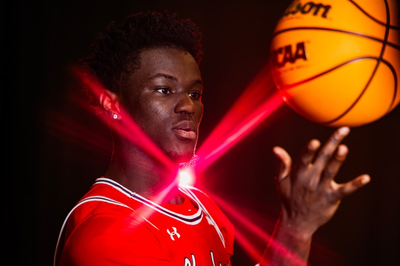 Masai Troutman posing with a basketball balanced on his finger.