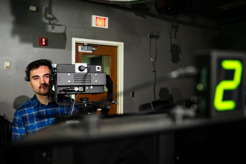 Jonas Fryer behind a camera in the NUTV recording studio.