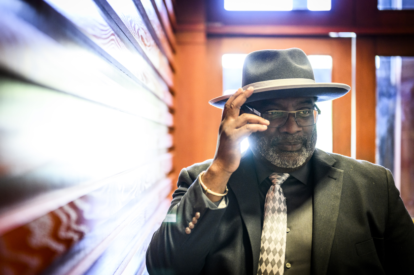 Robert Jose posing for a portrait with his hand posed to tip his hat.