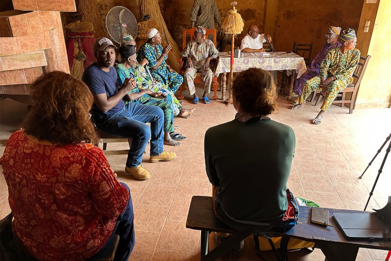 Killian Mokwete sitting with others in a building in Africa.