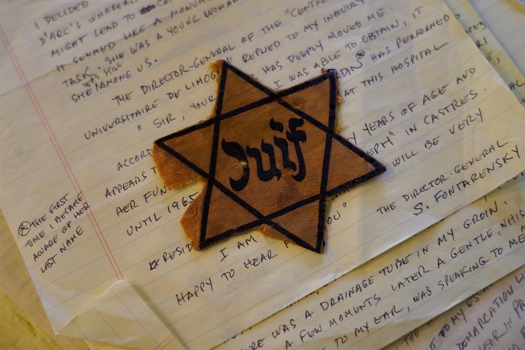 A Jewish star symbol on top of a notebook with writing on it.