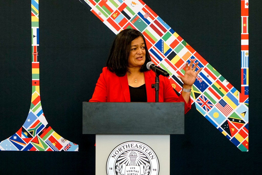 U.S. Rep. Pramila Jayapal speaking at a podium in front of a Northeastern logo on the Seattle campus