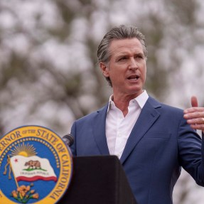 Governor Gavin Newsom speaking at a podium during a press conference.