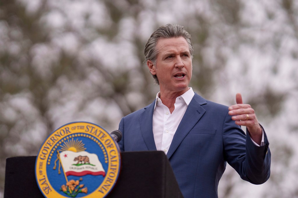 Governor Gavin Newsom speaking at a podium during a press conference.