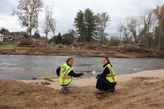 Two people wearing neon vests next to a river in North Carolina.