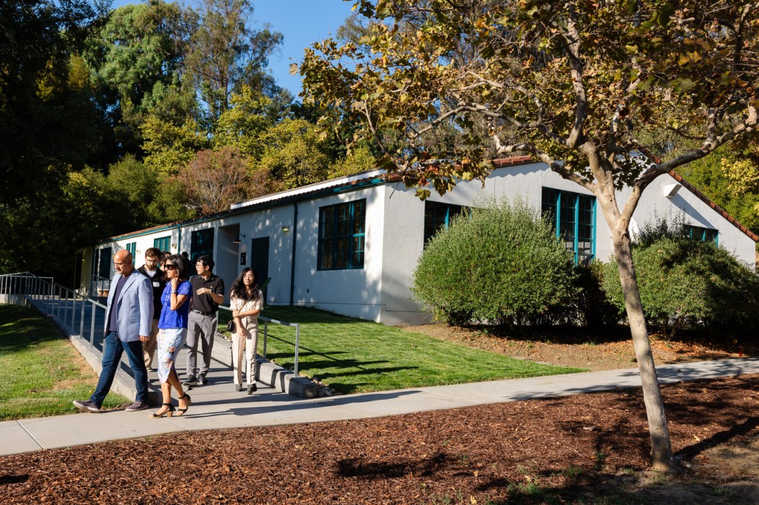 People walk down a ramp outside after exiting a lab.