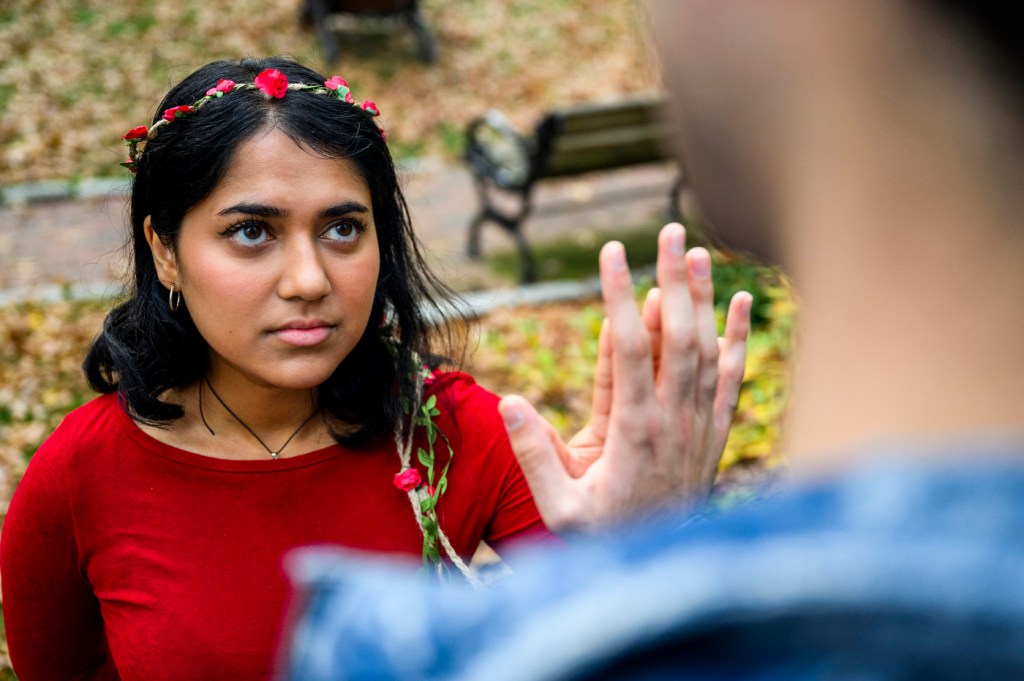 Two members of the Shakespeare Society with their hands pressed against each other.