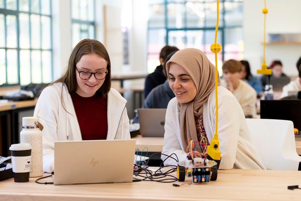 Two people working together in a modern classroom.