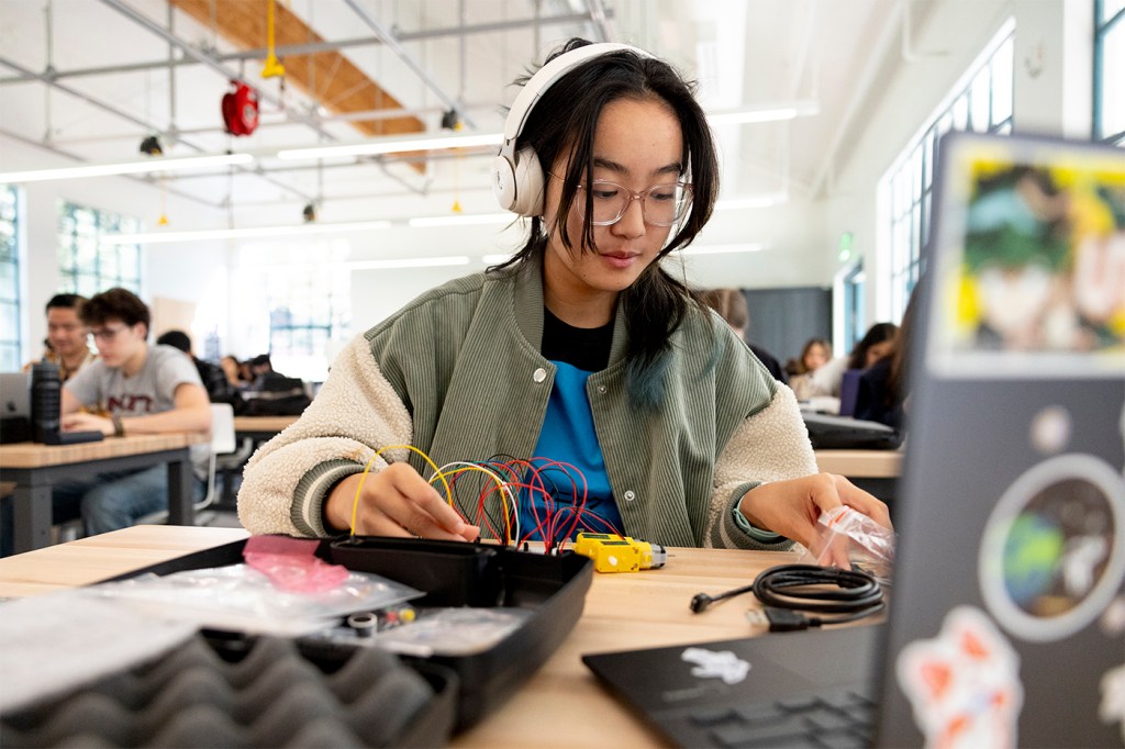 A student works on an electronics project in a classroom setting.