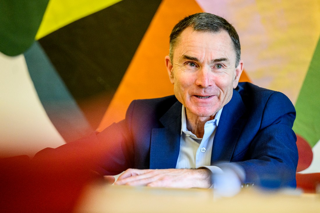 David Madigan speaking animatedly in front of a colorful background.