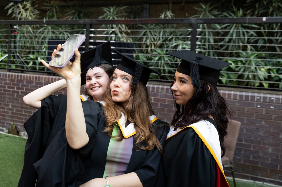 Three graduates posing for a selfie. 