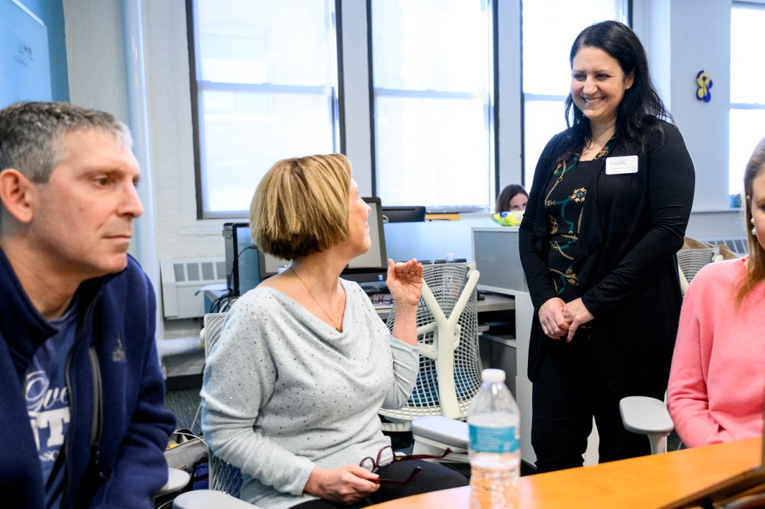 Two speaking talking and smiling at each other in the Communications Sciences and Disorders office. 