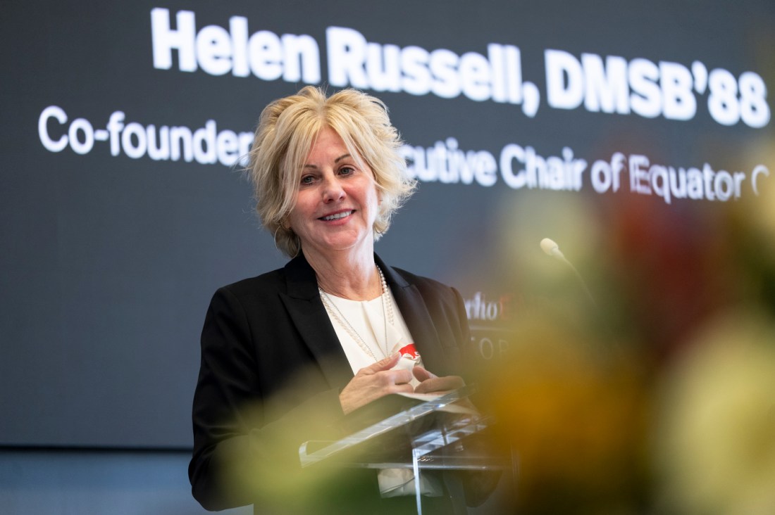 Helen Russell speaking on stage at a Women Who Empower event.