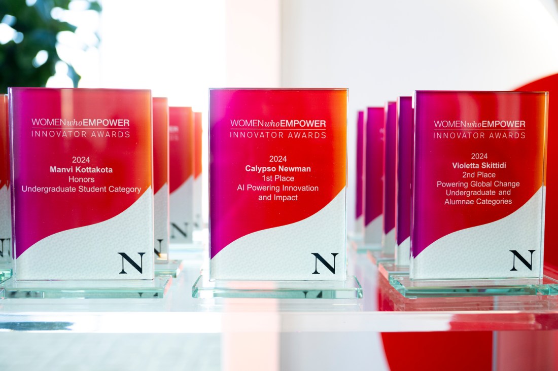 Women Who Empower awards lined up on a glass surface.