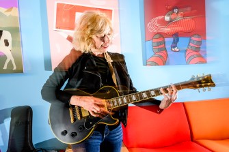 Joanna Weiss playing the guitar in her office.