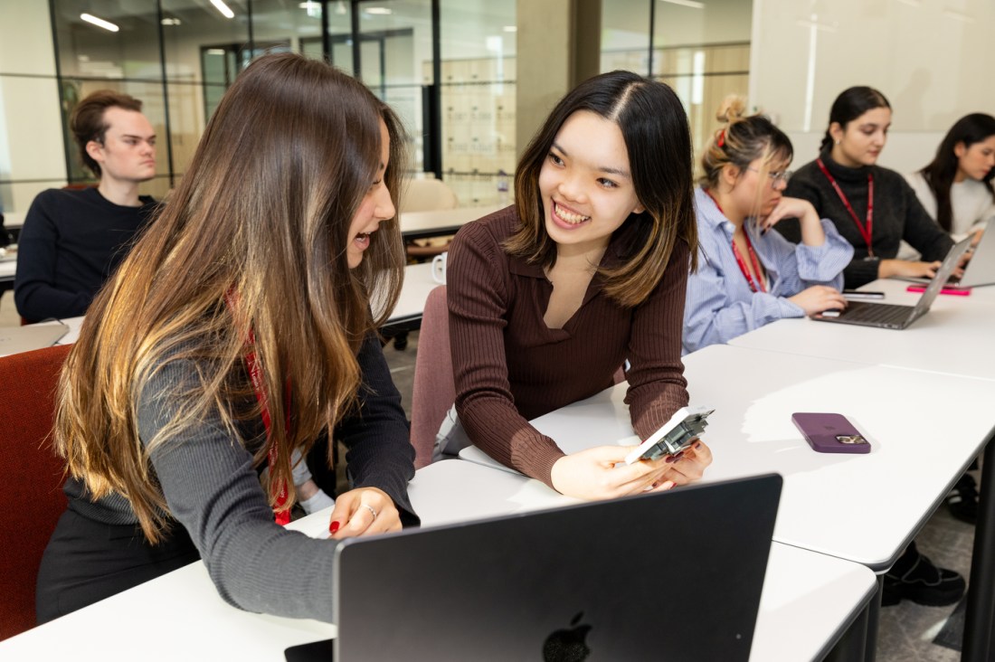 Two students looking at an AI powered plug socket.