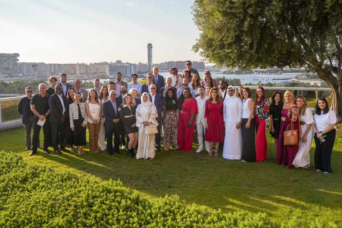 President Aoun and Diane Nishigaya MacGillivray posing with a large group of people in Dubai.