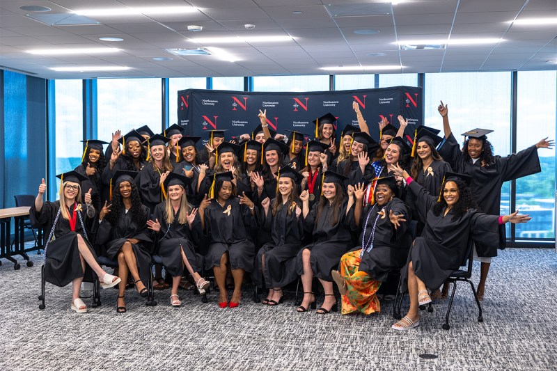 Cassandra Friend and other graduates posing in their caps and gowns.