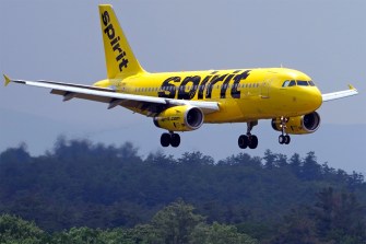 A yellow Spirit Airlines plane flying in for landing.