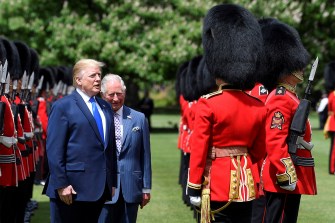 Donald Trump and the Prince of Wales inspect guards during a ceremonial event outdoors.