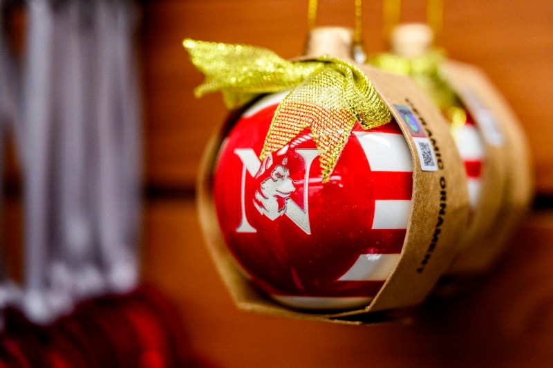 A red and white striped spherical ornament with the Northeastern N and a Husky.