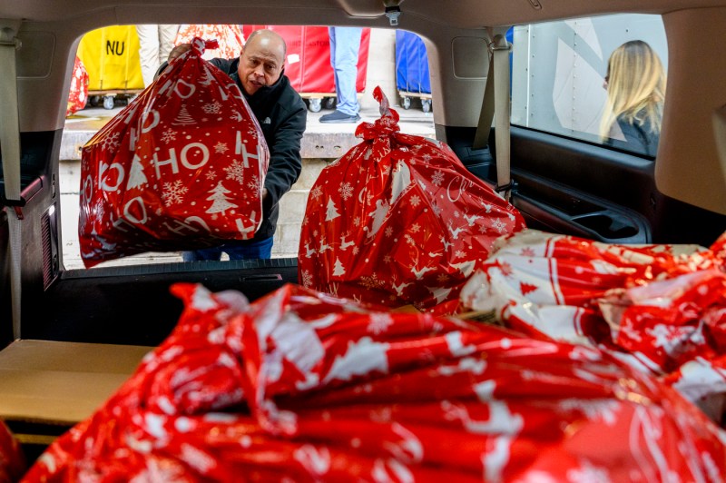 A Northeastern staff member loading bags of toys into a truck.