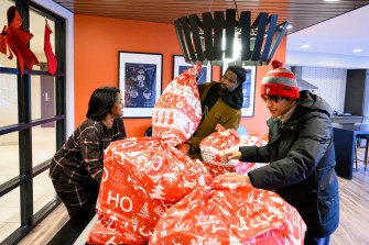 Northeastern staff members carrying bags of toys.